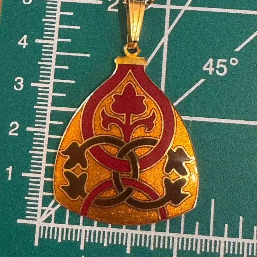 Gold tone signed Celtic knot pendant necklace in red, black and orange enamel